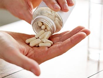 Medicamentos sendo colocados na mão