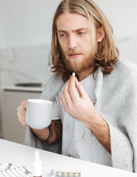 Paciente segurando uma caneca e um medicamento